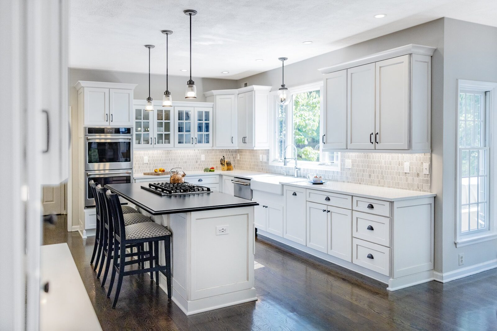 Close view of the island in a renovated Somerset Hills kitchen, with a dark countertop against white cabinetry