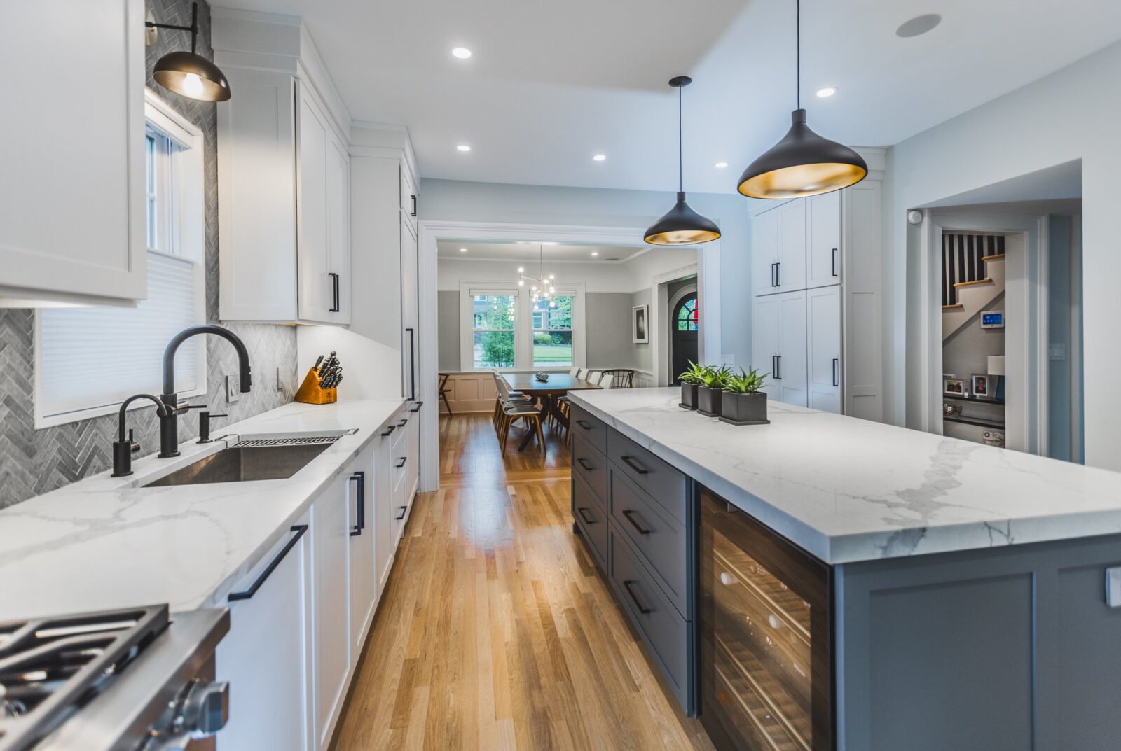 Galley-style kitchen in a Somerset Hills renovation, with a marble-look island counter opening to the dining area