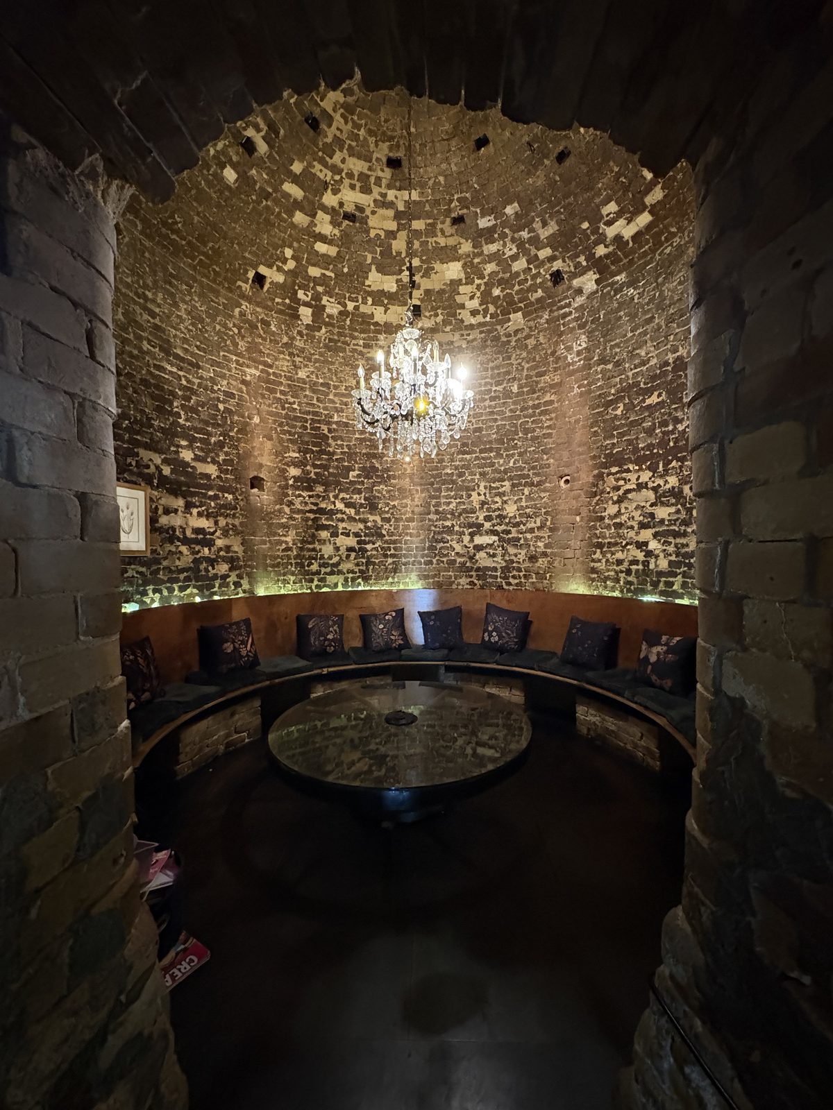 Alkemy Coffee Co., Flemington - the arched brick room with a round table, a curved bench and a chandelier