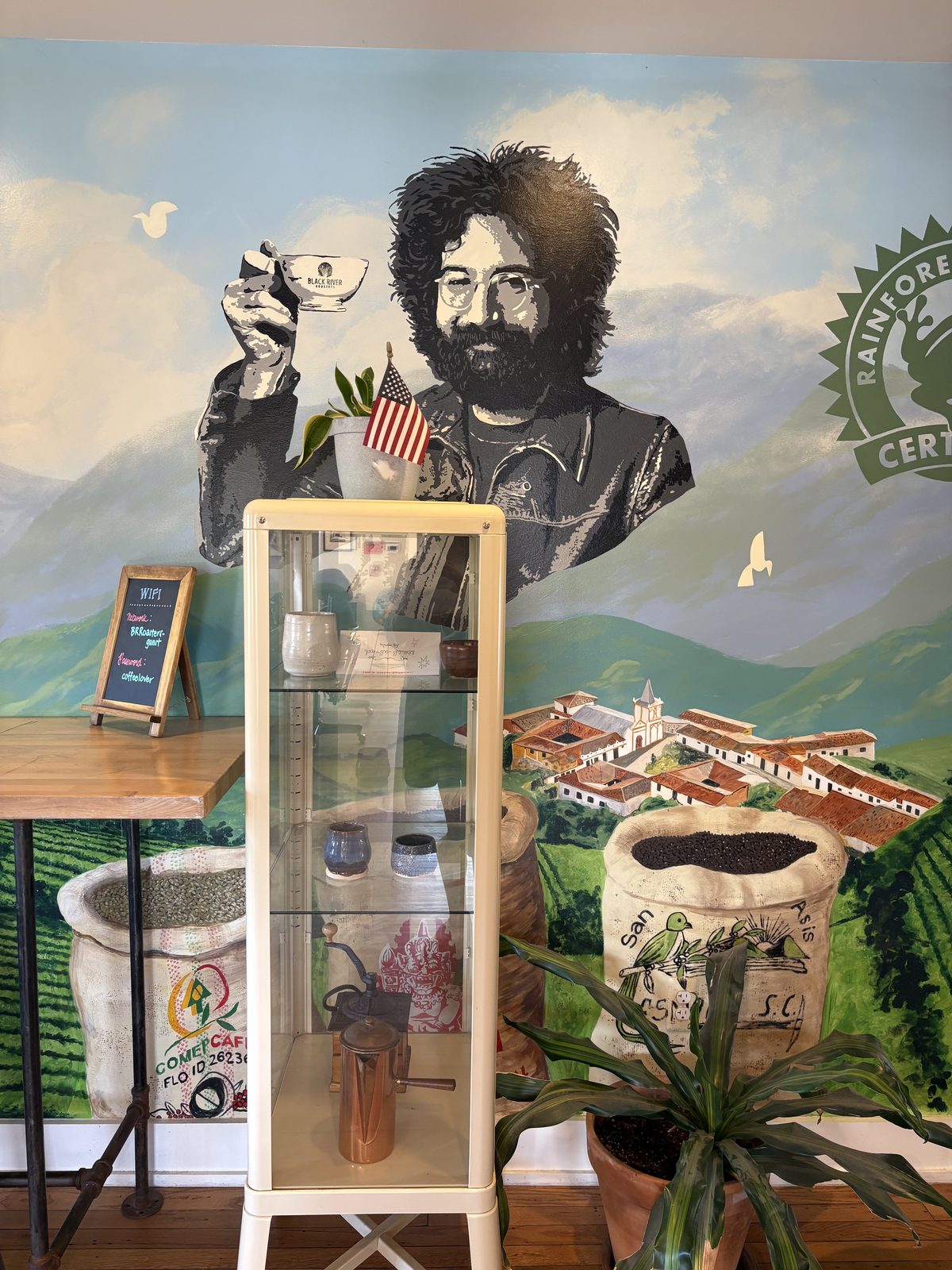 Black River Roasters, Whitehouse Station - a painted mural of coffee hills behind a glass display case