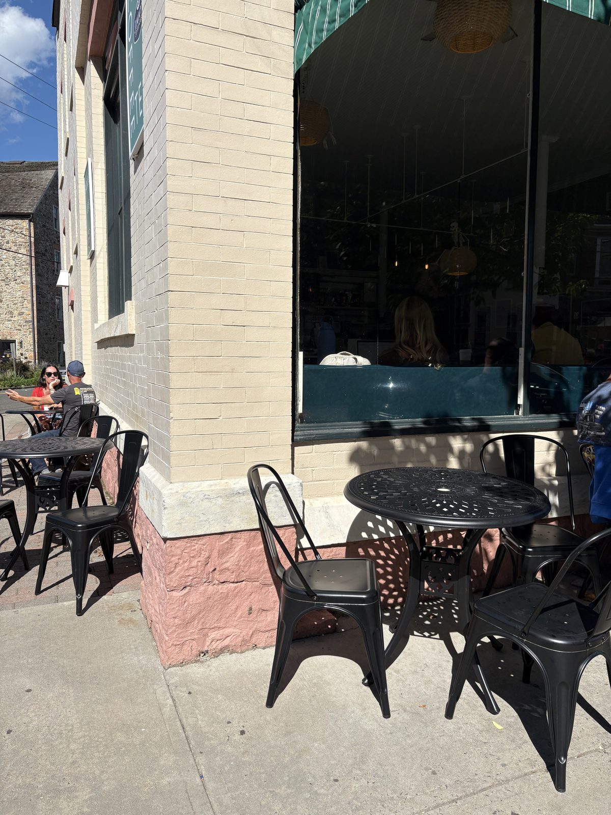 Jimmy's Coffeehouse, Clinton - black metal tables and chairs on the sidewalk at the corner of the building
