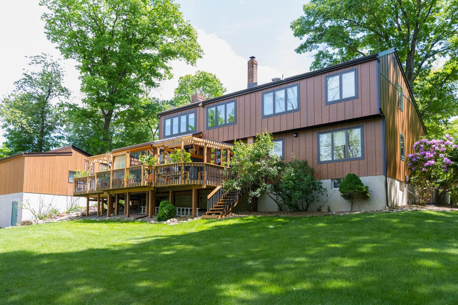 Magnolia Home Remodeling Group, Flanders NJ: rear of the home with board and batten vertical siding above a wood deck