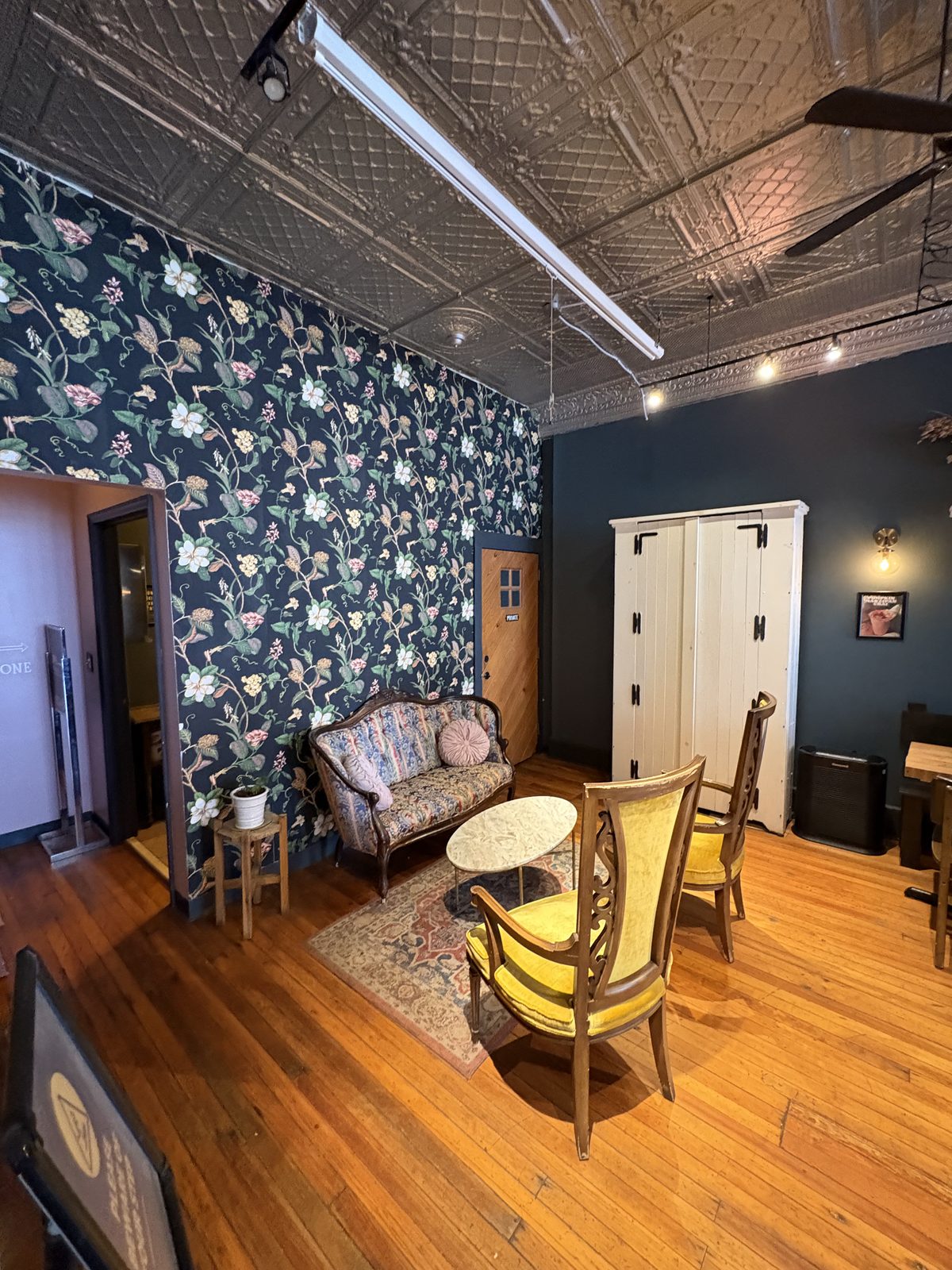 Scout's Coffee Bar + Mercantile, High Bridge - the second room with a floral wall, a settee and yellow armchairs