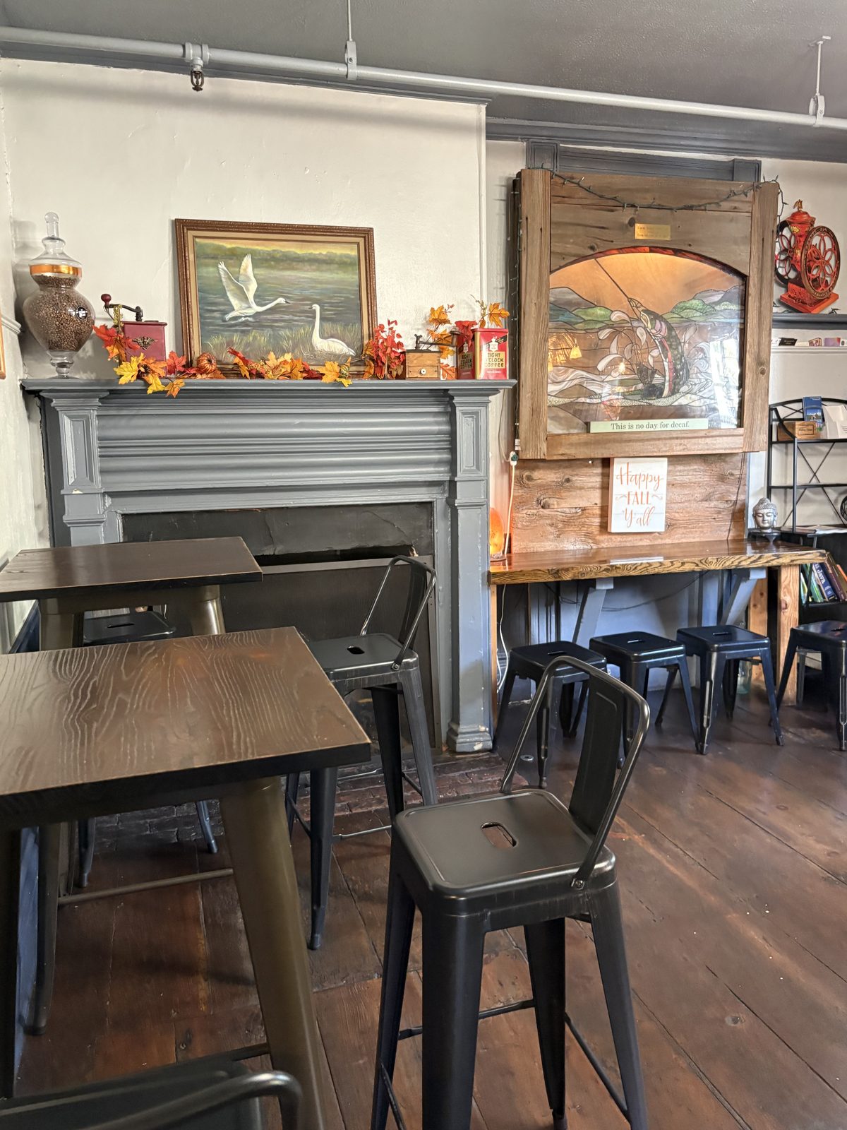The Stone Bean, Clinton - tables and metal stools beside the fireplace