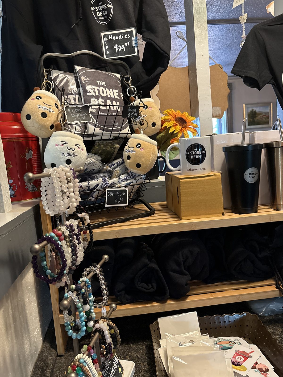 The Stone Bean, Clinton - a display of Stone Bean merchandise with plush toys, mugs, tumblers and hoodies